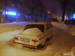 Заснеженная Одесса вечером: сугробы, застрявшие авто, пешеходы и последний троллейбус (ФОТО)
